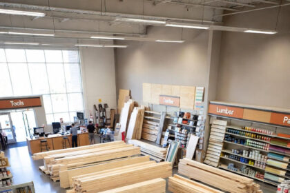 A well-organized hardware store aisle at Busy Beaver Weirton, showing lumber, tools, and friendly staff assistance.